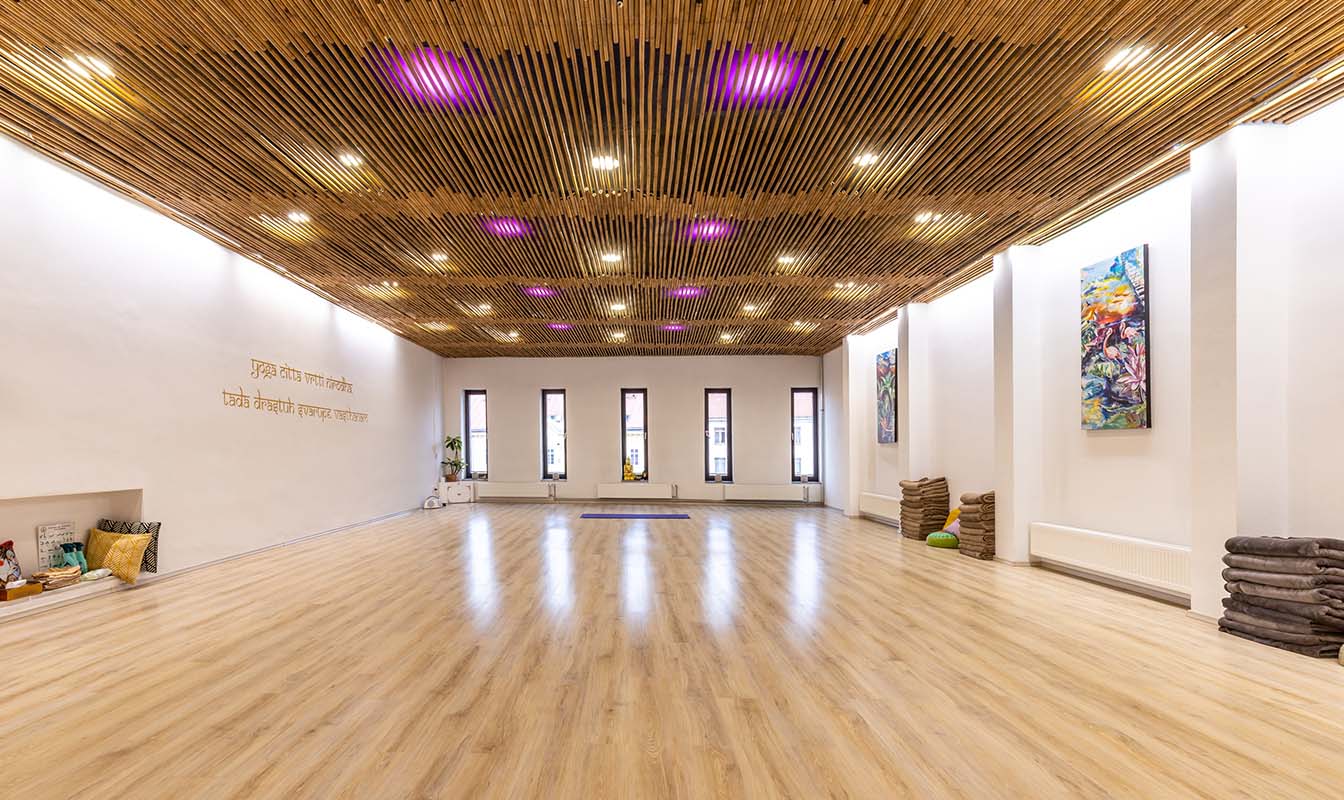 The main hall of the Samsára studio — bamboo ceiling and five tall windows